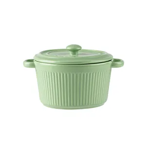 Green ceramic mini cocotte with lid and double handles for baking and soup serving.