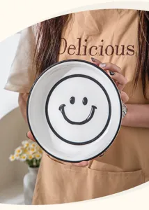 Gedetailleerd overzicht keramische kom, zwart smileygezicht, Japans servies voor de keuken.