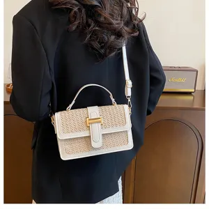 Stylish woven straw crossbody bag with white leather trim and metal clasp for casual summer resort.