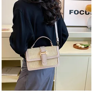 Details of the stylish woven straw crossbody bag with chic metal clasp and shoulder strap.