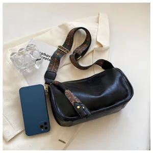 Black soft leather shoulder bag with ethnic wide strap casual crossbody pillow bag detail view.