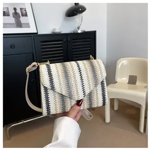 Detailed view of the colorful striped straw crossbody bag showing fine woven texture and hardware.