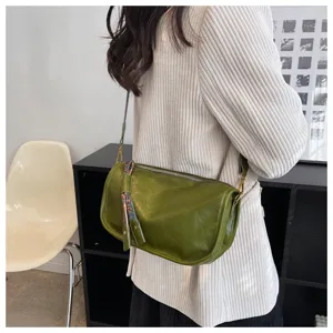 Detail view of the soft leather green shoulder bag, showing the texture and stylish strap decoration.