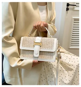 Stylish woven straw flap handbag detail shot with chic gold hardware and top handle design.