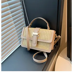 Close-up detail shot of the woven straw crossbody bag featuring PU leather trim and metal lock.