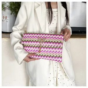 Chic bolso de mano tejido colorido con patrón en zigzag, mariposa dorada y borla.