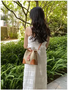 Summer woven straw bucket bag for women, stylish shoulder bag with drawstring closure.