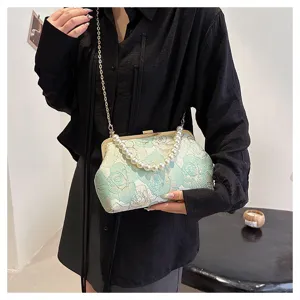Detail view of the elegant Chinese style embroidered jacquard clutch bag with pearl handle.