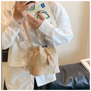Detailed view of stylish straw bucket bag with PU leather trim and convenient drawstring.