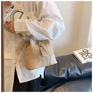 Summer woven bucket bag for women, chic straw shoulder handbag with PU leather patch details.