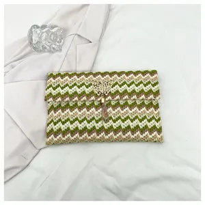 Detalle del elegante bolso de mano tejido con patrón de chevrón colorido y borla dorada chic.