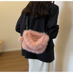 Detailed view of the stylish pink plush crossbody bag with chain strap and pom-pom.