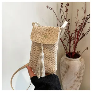 Straw woven crossbody phone bag with tassel and magnetic flap for women summer fashion style detail.