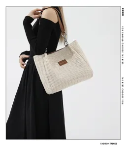 Detailed view of the woven straw tote bag with brown leather patch, summer resort style.
