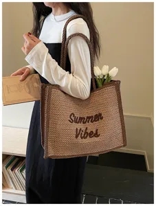 Detailed view of the large woven straw tote bag with braided handles and stylish summer vibe design.
