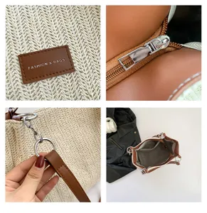Woven straw bucket bag detail view, showing brown leather patch, metal zipper and ring hardware.