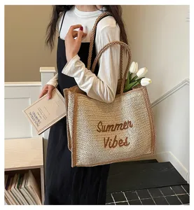 Woven straw tote bag detail showing texture, braided handles and summer vibe lettering.