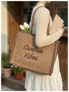 Close-up detail of the woven straw tote bag texture and design featuring Summer Vibes lettering.