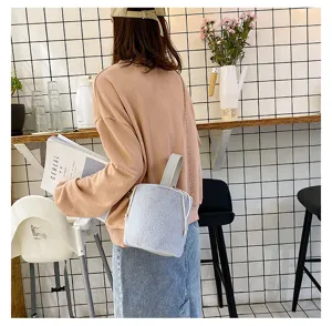 Fluffy plush bucket shoulder bag detail, featuring soft faux fur texture and chic chain strap.