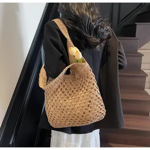 Detailansicht der gewebten Stroh Schultertasche mit Blumenrequisite und hohlem Design.