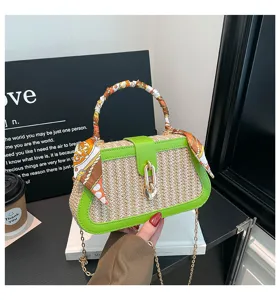 Details of the straw woven box handbag with green trim and elegant silk scarf handle.