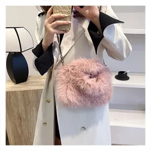Close-up detail of a stylish pink fluffy shoulder bag with chain strap for women autumn wear.