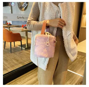 Detail view of the fuzzy plush bucket bag with drawstring closure and chic chain strap.