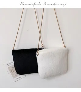 Detailed view of cute plush cross body chain bag in black and white winter style soft material.