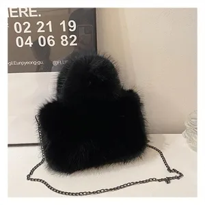 Black fluffy plush shoulder bag detail shot, stylish winter handbag with chain strap.