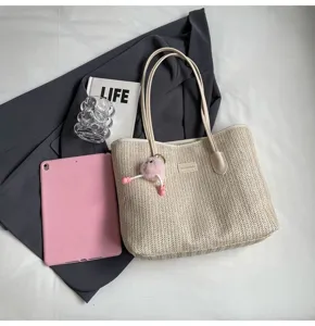 Detailed view of the stylish straw woven tote bag with cute fluffy charm and large capacity.