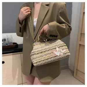 Chic woven straw shoulder bag with metal kiss-lock frame and delicate floral embroidery for women.
