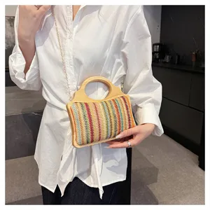 Vista detallada de un bolso cruzado de paja colorida con asa de madera y elegante cadena.