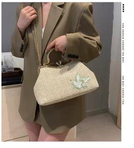 Chic straw woven shoulder bag with floral embroidery, elegant metal frame and chain strap.