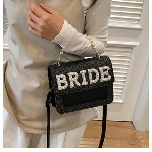 Borsa a tracolla intrecciata nera con manico di perle e dettagli di lettere BRIDE per nozze.
