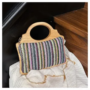 Vista detallada del bolso de mano tejido colorido de moda con asa de madera y cadena dorada.