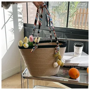 Woven straw tote bag with colorful scarf handle and floral tulip decor for summer beach.