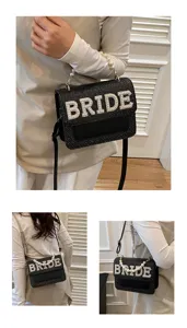 Primo piano della borsa a tracolla da sposa intrecciata nera con manico di perle.