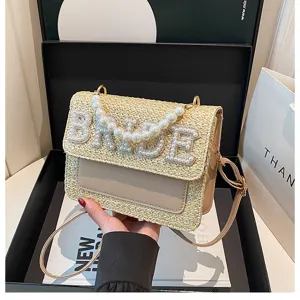 Borsa a tracolla in paglia intrecciata con perle e design di lettere da sposa eleganti.
