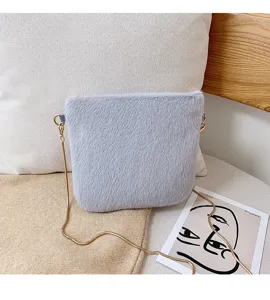 Detail view of plush fuzzy crossbody bag, soft faux fur texture with gold chain strap.
