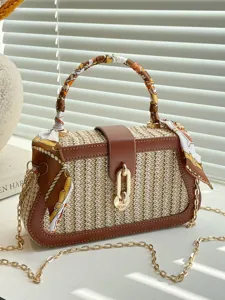 Chic straw woven handbag with brown leather trim, stylish scarf handle and chain strap for women.