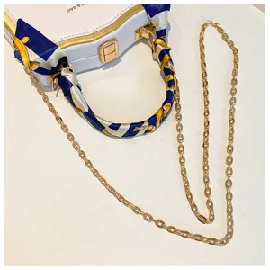 Élégant sac de soirée pour femme avec poignée en foulard de soie et chaîne dorée.