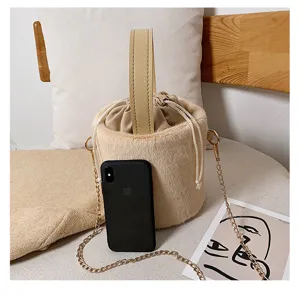 Chic plush bucket shoulder bag with drawstring closure, top handle and chain strap for women.