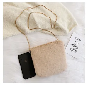Detail view of a cute fluffy crossbody bag in camel plush, featuring a sleek gold chain strap.