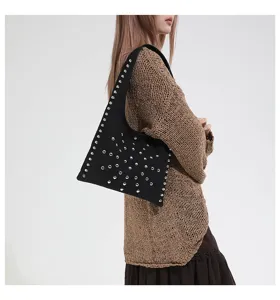 Detail shot of black shoulder bag with silver stud rivets and stylish design for women.