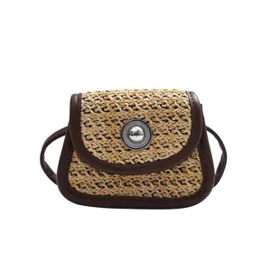 Detail view of mini woven crossbody bag featuring brown leather trim and metallic clasp button.
