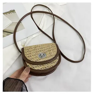 Chic woven straw crossbody bag with brown leather trim and metal lock for women fashion style.
