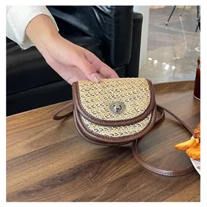 Stylish straw woven crossbody saddle bag for women, chic contrast leather trim mini handbag.