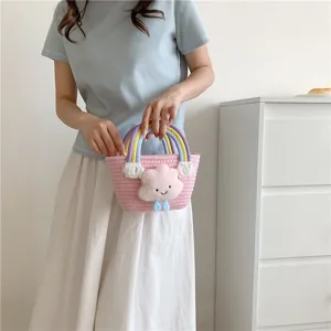 Close-up of the mini woven bucket bag featuring colorful handles and cute plush cloud detail.