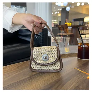 Stylish mini straw woven handbag with brown leather trim and metal lock. Perfect daily accessory.