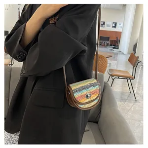 Detailed shot of a stylish mini woven crossbody bag with contrast colors and leather trim.